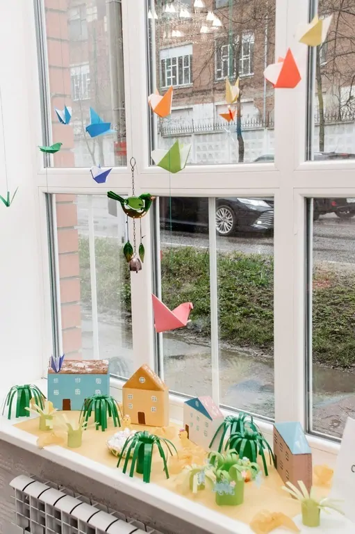 Фото: самый быстрый и простой способ украсить окно к Пасхе – развесить на нем птичек из разноцветной бумаги, © okna911 