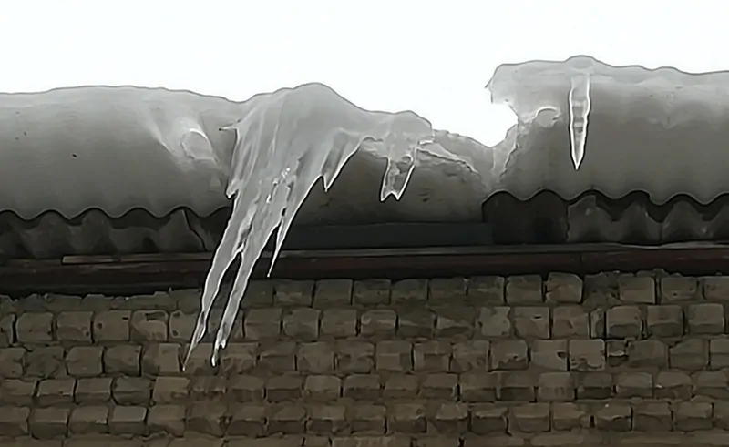 Фото: смертоносная сосулька и ледяные массы свисают с крыши многоэтажного дома, © oknamedia.ru, Сосулька упала на голову, что делать 
